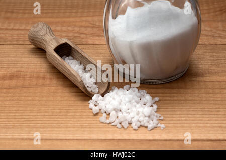 Salz mit hölzernen Schaufel und Glas Salzstreuer auf Holztisch Stockfoto