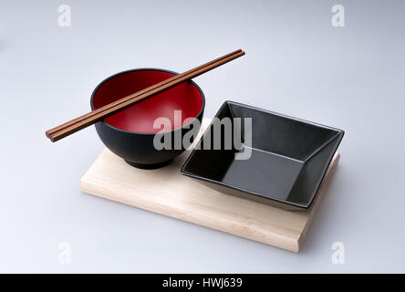 Stäbchen mit Gericht angeordnet auf einem Bambus-Tablett auf eine chinesische Schüssel gelegt. Stockfoto