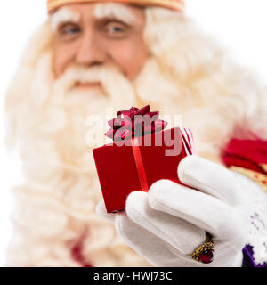 freundlichen Weihnachtsmann mit kleinen Geschenk. Selektiven Fokus auf der Seite mit Geschenk Stockfoto