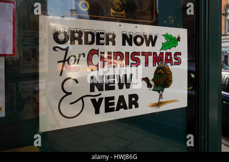 Ein Zeichen ermutigt Menschen, "Ordnung jetzt für Weihnachten und Neujahr" bei einem Metzgereien in Bristol, England. Die Zeichen zeigt einen Truthahn. Stockfoto