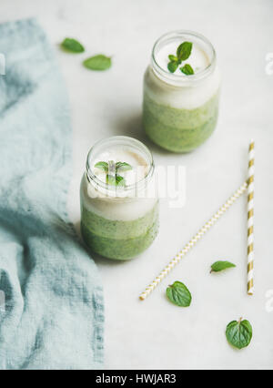 Ombre grüne Smoothies mit Minze in Gläsern über hellen grauen Hintergrund, selektiven Fokus geschichtet. Sauber, Essen, Vegan, vegetarisch, Gewichtsverlust, healt Stockfoto