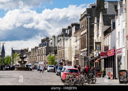 Street Scene mit Autos auf der Straße außerhalb der kleinen Läden in der Innenstadt geparkt. Die Market Street, Royal Burgh St Andrews, Fife, Schottland, Großbritannien, Großbritannien Stockfoto