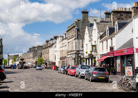 Street Scene mit parkenden Autos am Straßenrand durch Geschäfte im Stadtzentrum im Sommer. Die Market Street, Royal Burgh St Andrews, Fife, Schottland, Großbritannien, Großbritannien Stockfoto