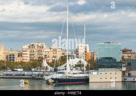 Wohlstand auf dem Display mit großen Yachten & Segelboot vertäut am Ufer Räume.  Eigentumswohnungen mit Ausblick in der Nachmittagssonne in Barcelona.  In der Nähe Exponate. Stockfoto