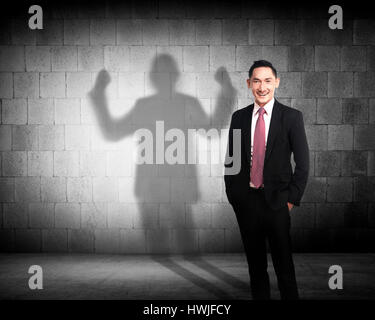 Asien-Geschäftsmann wirft einen Schatten der Stärke Karriere Konzept Stockfoto