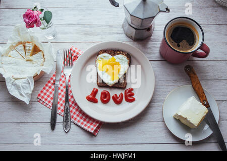 Gebratenes Ei mit Ketchup und Käse Brie. Lecker duftenden Morgenkaffee. Stockfoto