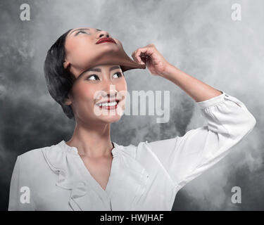 Asiatische Geschäftsfrau entfernen seine anderen Gesichtsmaske. Wechselnde Stimmung Konzept Stockfoto