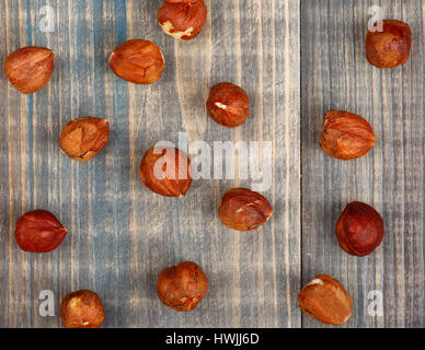 Muttern der Haselnuss sind verstreut auf einem Holztisch Stockfoto