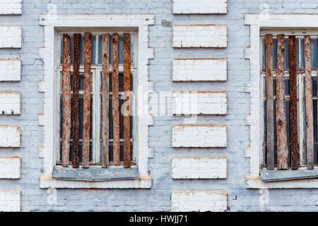 Teil der Fassade des alten Backsteinbau mit Brettern vernagelt Windows. Stockfoto