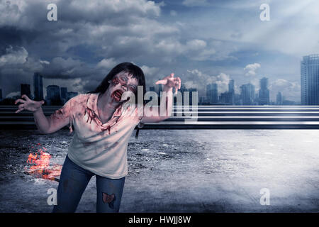 Beängstigend weibliche Zombie mit brennenden Stadt Hintergrund. Halloween-Konzept Stockfoto