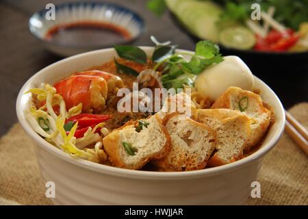 Laksa Curry. In Keramikschale serviert Peranakan Curry Nudelsuppe mit Meeresfrüchten, Bean Quark und Sprossen. Stockfoto