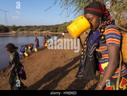 Borana Stamm Frau Trinkwasser aus einem Reservoir verwendet für Tiere, Oromia, Yabelo, Äthiopien Stockfoto