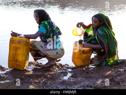 Borana Stamm Menschen füllen Kanister in ein Wasser-Reservoir verwendet für Tiere, Oromia, Yabelo, Äthiopien Stockfoto