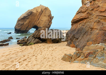 Sandigen Strand Praia de Santa Cruz mit Felsformation (Portugal). Nebligen Wetter. Stockfoto