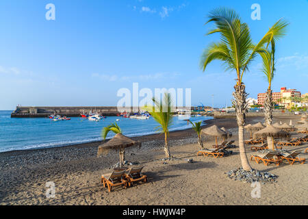 Palmen auf schwarzen vulkanischen Sandstrand im Hafen von San Juan, Teneriffa, Spanien Stockfoto