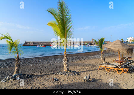 Palmen auf schwarzen vulkanischen Sandstrand im Hafen von San Juan, Teneriffa, Spanien Stockfoto