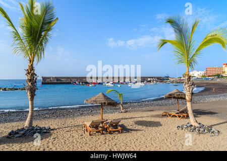 Palmen auf schwarzen vulkanischen Sandstrand im Hafen von San Juan, Teneriffa, Spanien Stockfoto