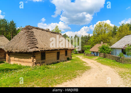 Alte traditionelle Häuser mit Stroh Dächer in Tokarnia Dorf am sonnigen Frühlingstag, Polen Stockfoto