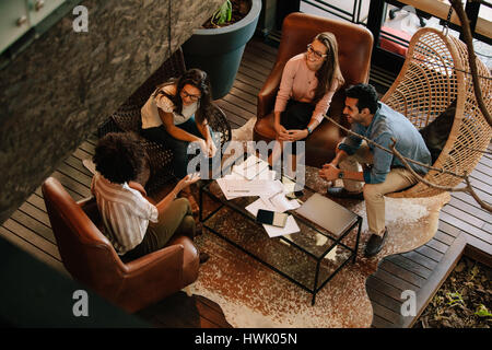 Draufsicht der vier Kollegen auf Büro Lobby sitzen und neue Ideen zu diskutieren. Unternehmen-Team-Meeting im Büro. Stockfoto