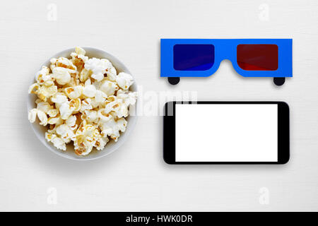 Popcorn, Smartphone und Anaglyphen 3D-Brille auf weißen Tisch Stockfoto