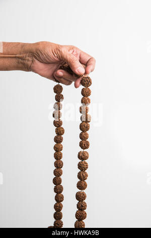 Nahaufnahme Bild von Hand dabei Meditation mit Rudraksha Mala oder Rosenkranz Perlen, selektiven Fokus Stockfoto