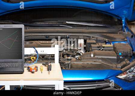 Nahaufnahme der Mechaniker Auto Tabelle auf unscharfen Fahrzeug Hintergrund. Fahrzeug-Auto-service Stockfoto