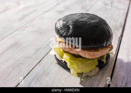 Schwarzen Burger auf hölzernen Hintergrund. Stockfoto