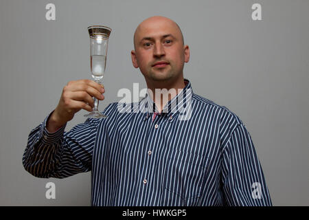 Der Mann im blauen Hemd mit einem Glas Champagner Stockfoto
