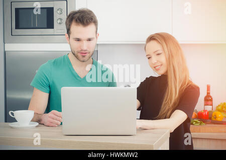 Paar verwendet der Computer in der Küche. Lebensstil paar Küche kochen zu Hause glücklich Frühstück junge Konzept Stockfoto