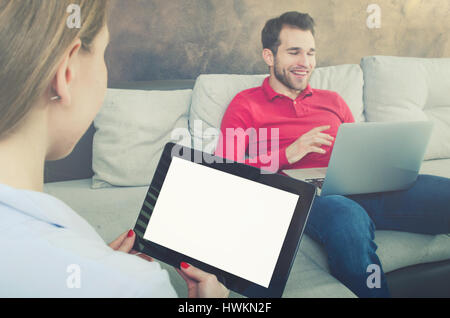 Frau mit einer Tablette. Mann im Hintergrund. Frau Tablet halten leere hinter paar auf der Suche Suche Konzept Stockfoto