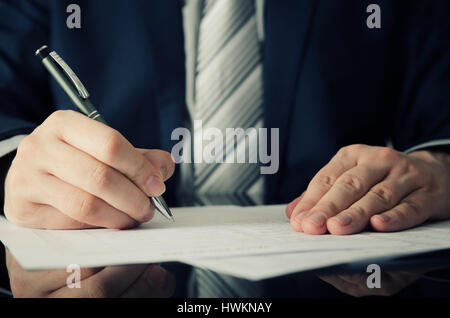 Geschäftsmann unterschreibt einen Vertrag. Mann Vertragsunterzeichnung Handschrift Stift schreiben Papier Konzept Stockfoto