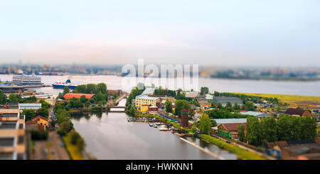 Spielzeug am Fluss Landschaft. Fluss, Meer, Meeresstation und Industriebauten. Tilt-Shift-Effekt, Sankt Petersburg, Russland Stockfoto