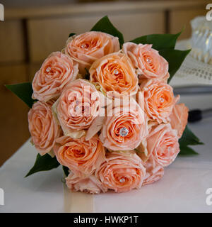 Rosen Hochzeit Bouquet auf einem Tisch in der Nähe der Hochzeitstorte Stockfoto