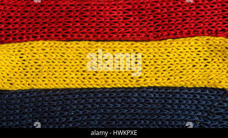 Gestrickte Fragmente Flagge Farben - rot, blau, gelb Stockfoto