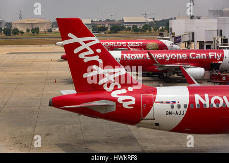 BANGKOK, THAILAND - 3. März 2014: Ausladen des Gepäcks vom Flugzeug Air Asia in Bangkok Flughafen. Air Asia Company ist die größte low-cost Fluglin Stockfoto