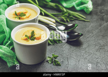 Zwei Schüsseln mit Püree Gemüsesuppe mit Croutons und Gemüse im Hintergrund Stockfoto