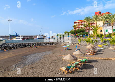 Strand von SAN JUAN, Teneriffa - 15. November 2015: Sonnenliegen Wuth Sonnenschirme am Strand in San Juan Stadt auf der Insel Teneriffa, Spanien. Stockfoto