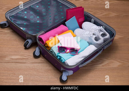 Reisen und Urlaub-Konzept. Öffnen des Reisenden Beutel mit Kleidung, Accessoires, Kreditkarte, Karten und Pass. Stockfoto