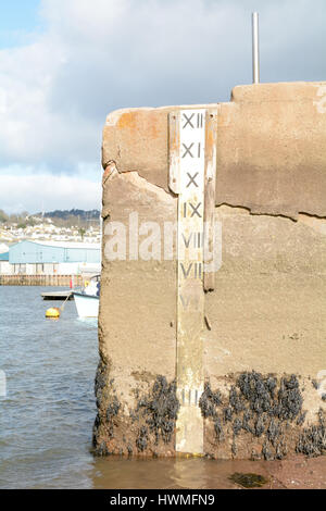 Wasser-Tiefe-Marker mit Tiefe in den Füßen am Deich in Teignmouth, Devon England Stockfoto