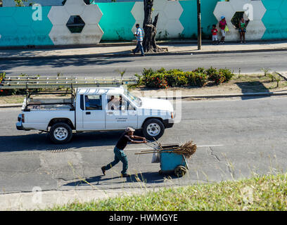 Santiago De Cuba, Kuba - 11. Januar 2016: typische Szene einer der Straßen im Zentrum von Santiago De Cuba-Menschen herumlaufen, Auto und Straße sw Stockfoto