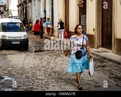 Havanna, Kuba - 5. Januar 2016: Typische Szene einer der Straßen im Zentrum von La Havanna - Kolonialarchitektur, Autos und Menschen herumlaufen Stockfoto