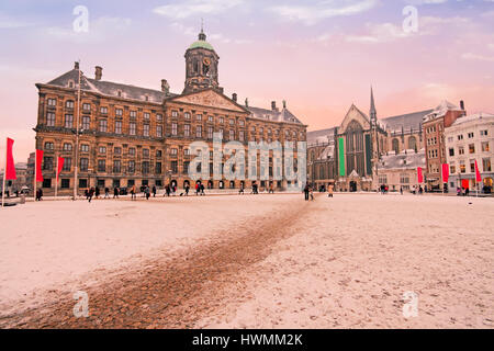 Verschneite Dam in Amsterdam Niederlande im Winter bei Sonnenuntergang Stockfoto