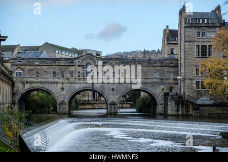 Die Pulteney Bridge über den Fluß Avon in Bath England mit Geschäften, die über die Spannweite und die Wehr unten gebaut Stockfoto