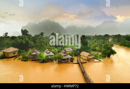 Vang Vieng Laos Wahrzeichen Hüttendorf mit die hölzerne Brücke in trübe und morgen niedrige Lighthing Stockfoto