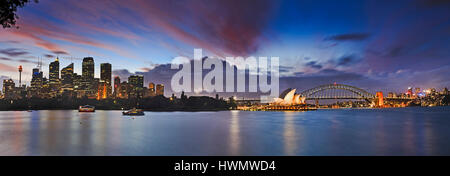Sonnenuntergang über Sydney Harbour von hohen Wolkenkratzern, Harbour Bridge, North Sydney und anderen architektonischen Wahrzeichen der Stadt, im unscharf Stockfoto