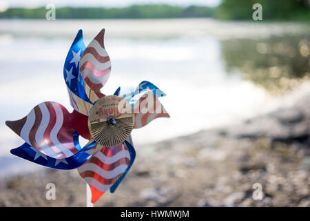 Eine amerikanische Flagge Pin Rad sitzt im Schlamm an der Seepromenade. Stockfoto