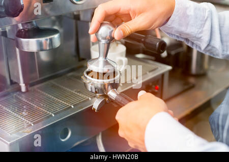 Grafik der Fackel gegen abgeschnittenen Hände des Barista Tasse Kaffee Stockfoto