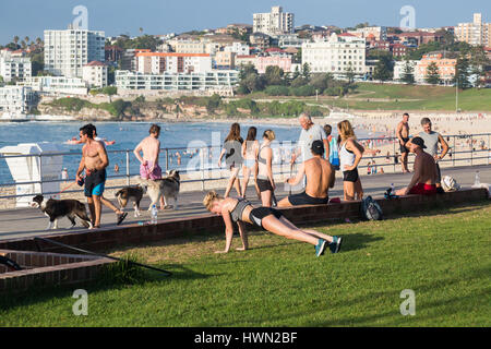 Eine typische Szene am Bondi Beach schon früh am Morgen, als einheimische machen Sie sich fit und gehen Sie ihre Hunde an Bondi Beach Promenade, Sydney, Australien. Stockfoto