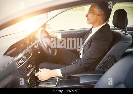 Gut aussehend Geschäftsmann in den Fahrersitz in seinem Auto Stockfoto