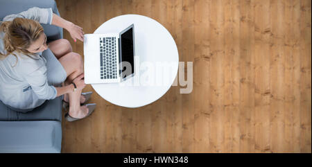 Frau auf ihrem Laptop gegen Holzbohlen Stockfoto